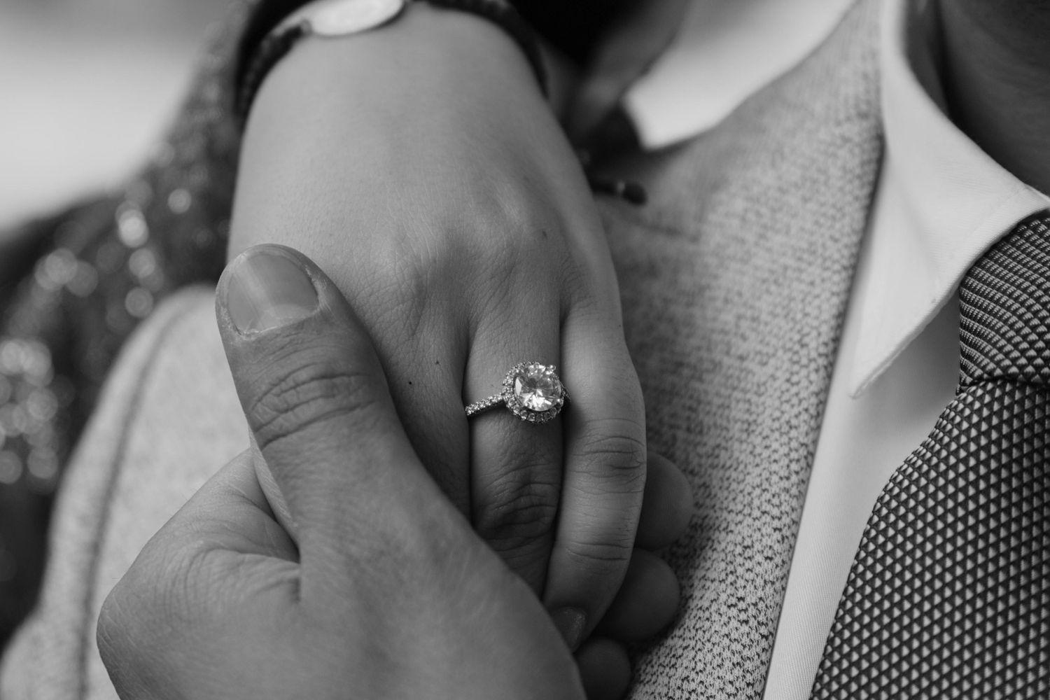 la main de la fiancée sur l'épaule du fiancé.