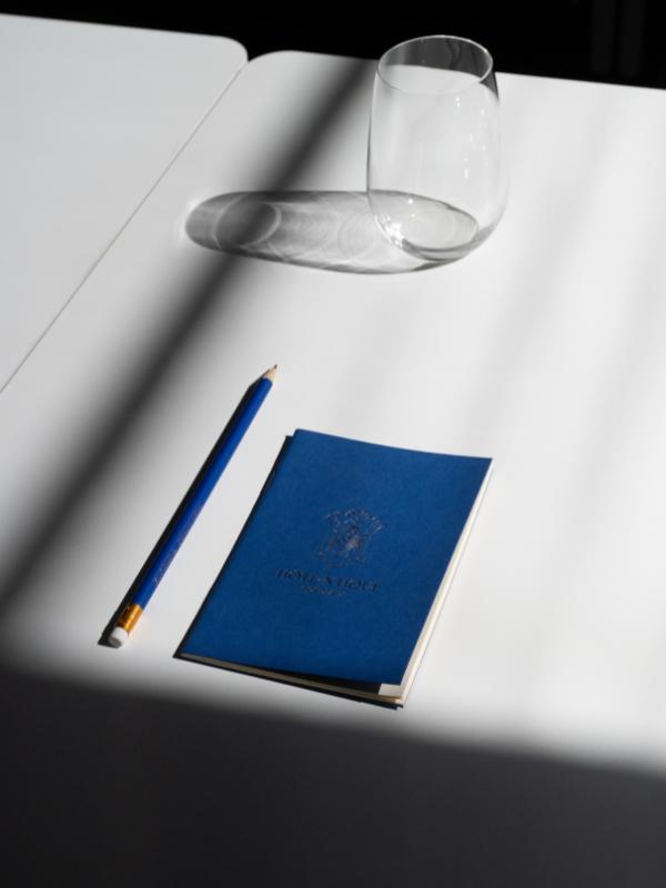 Carnet, crayon et verre à eau sur une table, dans une salle de formation